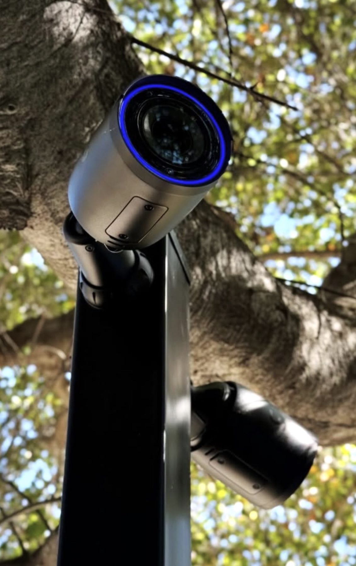 AI-camera met lange lens op een paal, gericht op de oprit