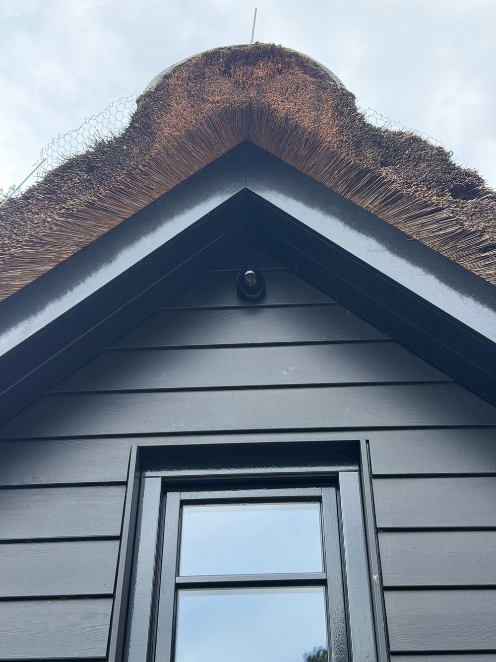 Camera hoog in de topgevel onder een rieten kap, buiten handbereik