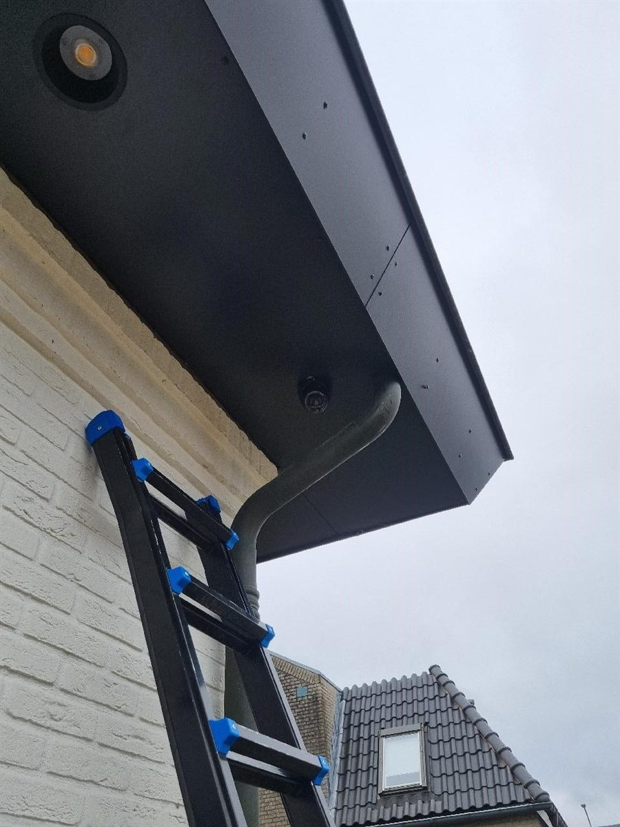 Donkere dome-camera weggewerkt onder een zwarte dakrand, geen kabel te zien