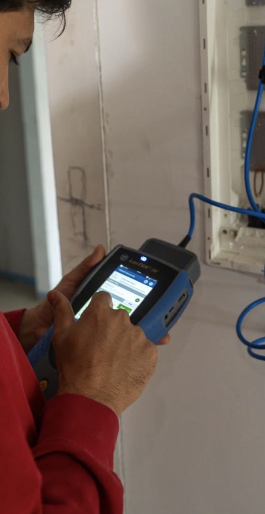 Monteur meet een netwerkkabel door met een handtester