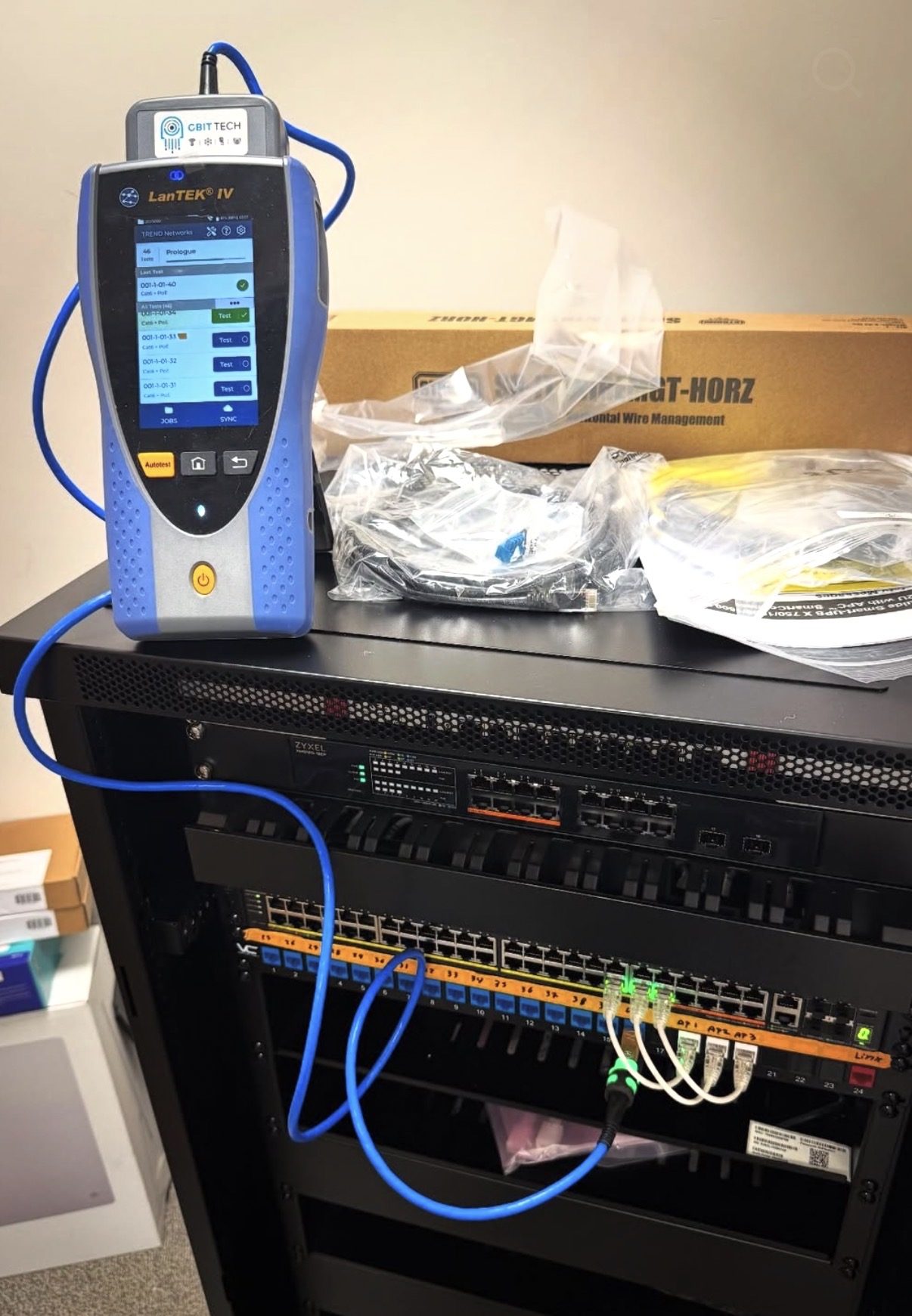 Kabeltester bovenop het rack tijdens het certificeren van de bekabeling
