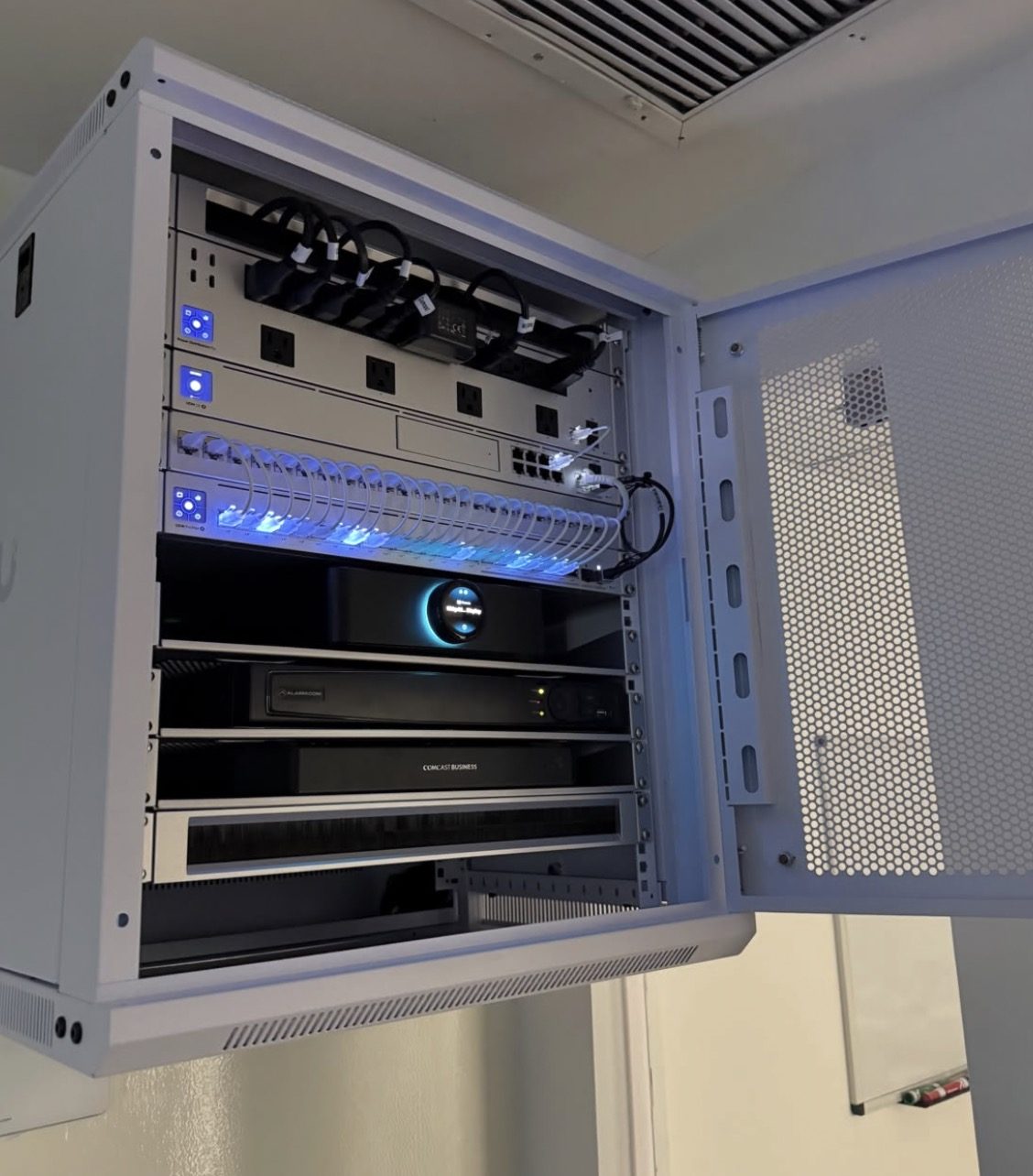Netwerkkast met netwerkrecorder en switch achter glas