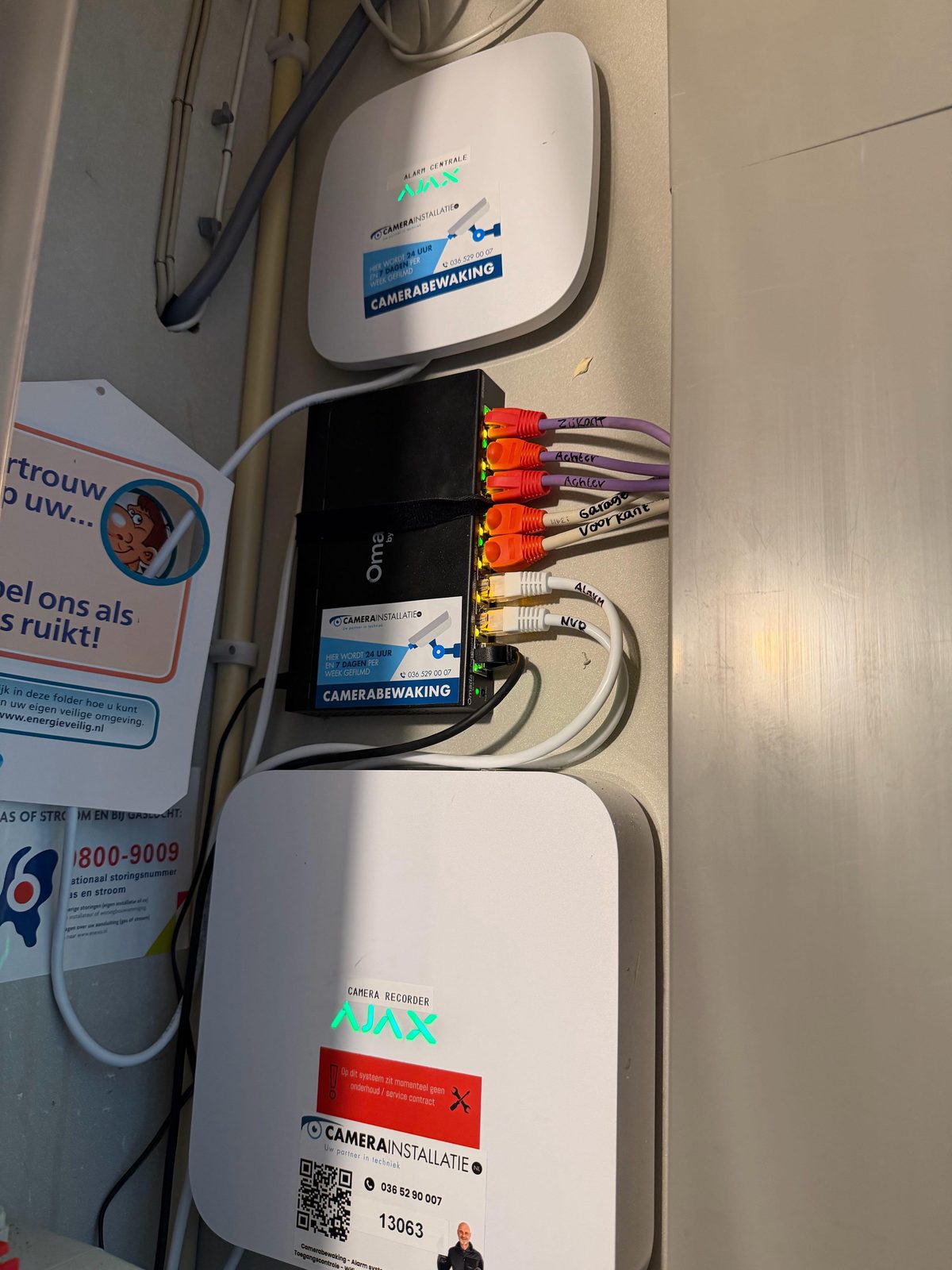 PoE-switch met per camera gelabelde netwerkkabels: zijkant, achter, garage en voorkant