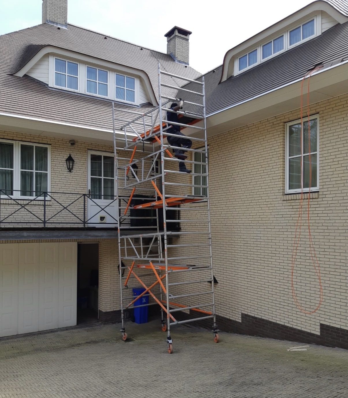 Rolsteiger tegen een villa terwijl de camera onder de dakrand wordt gemonteerd