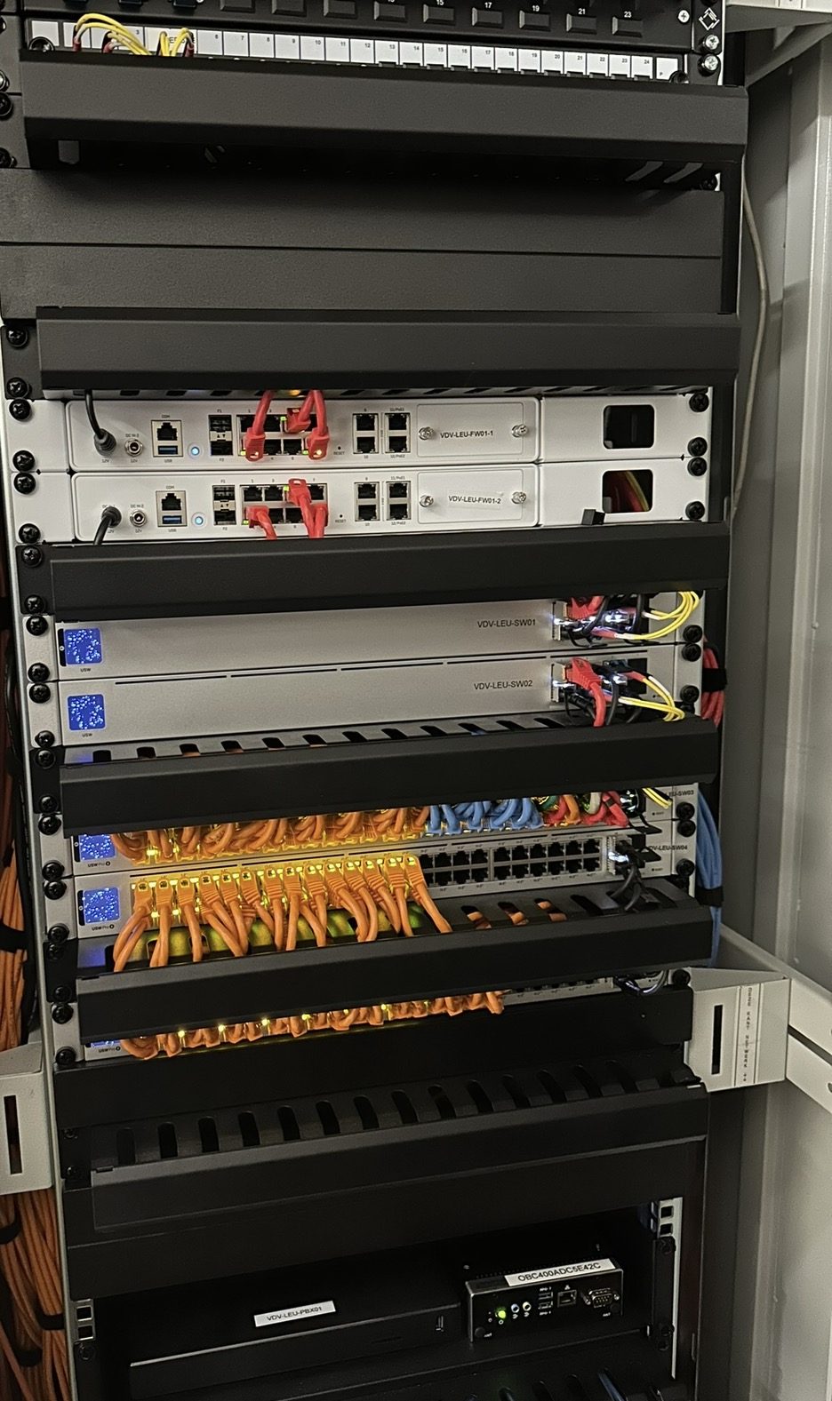 Serverrack met patchpanelen en oranje patchkabels