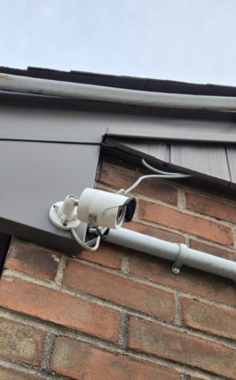 Bullet-camera met een kabel die los onder de dakrand door loopt