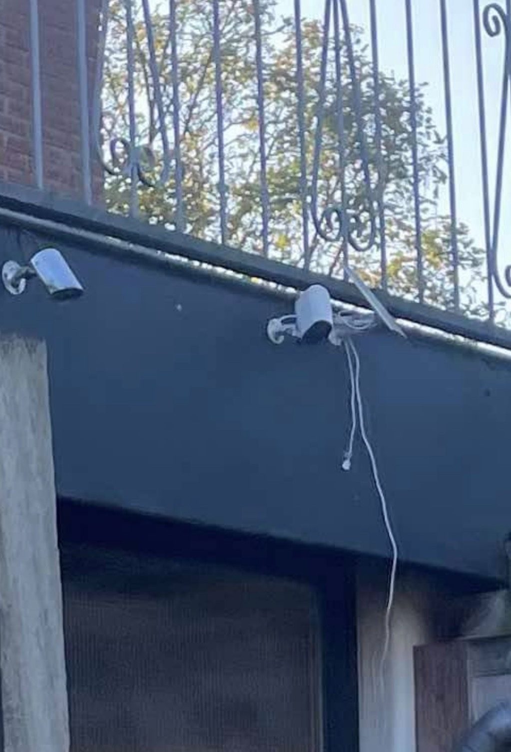Camera met een losse kabel die langs de muur naar beneden hangt