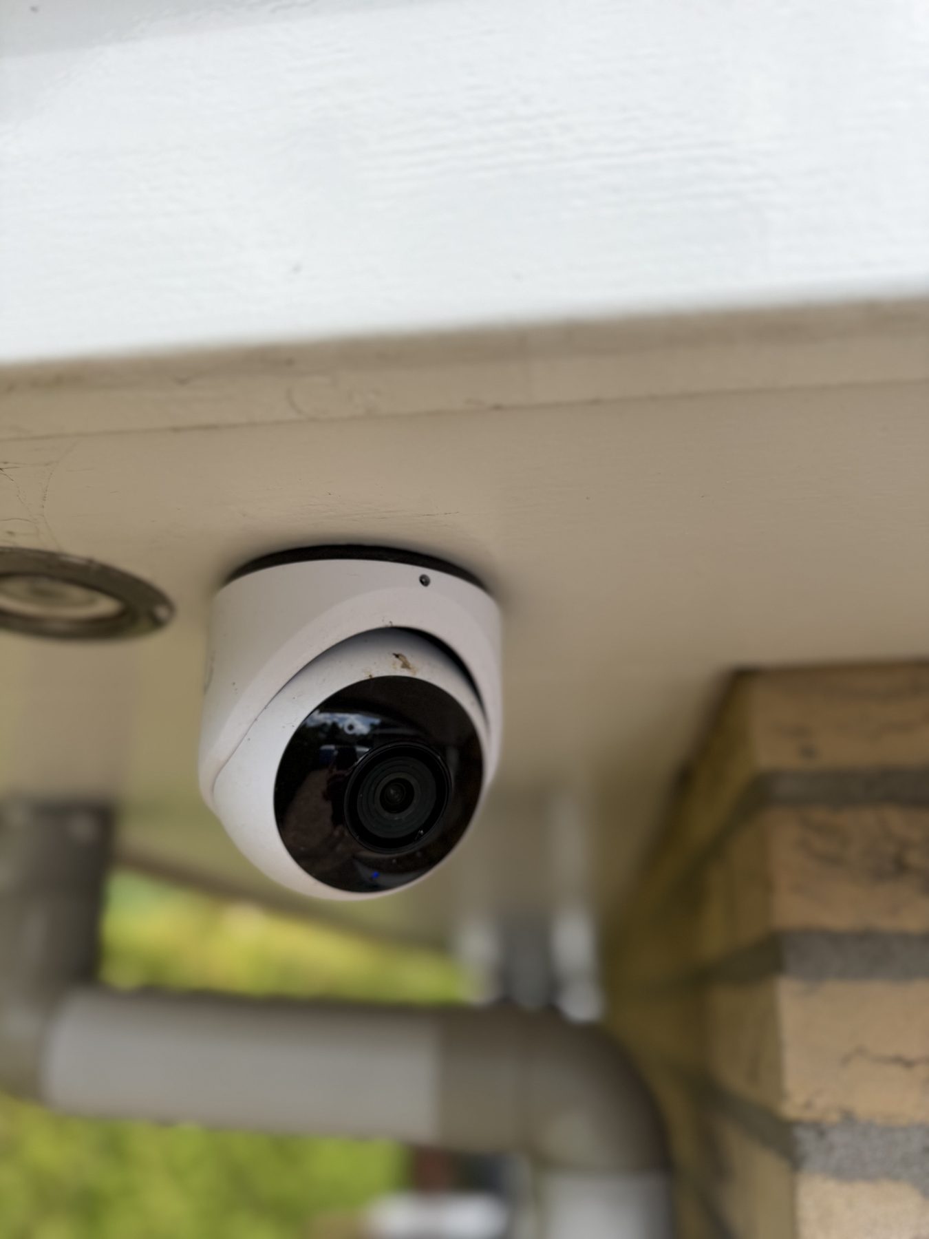 Turret-camera onder een houten overkapping bij het terras