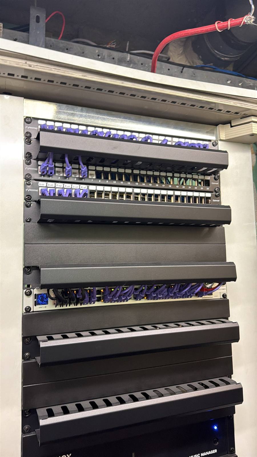 Netwerkkast met patchpanelen en UniFi-apparatuur in een hotel, door ons geinstalleerd