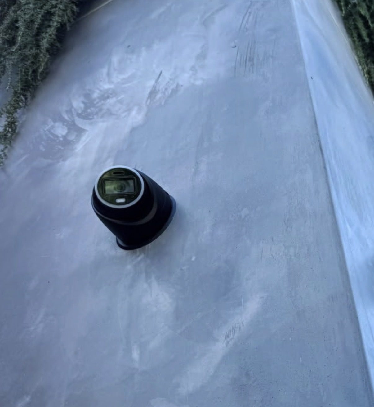 Zwarte turret-camera tegen een lichte gestucte gevel
