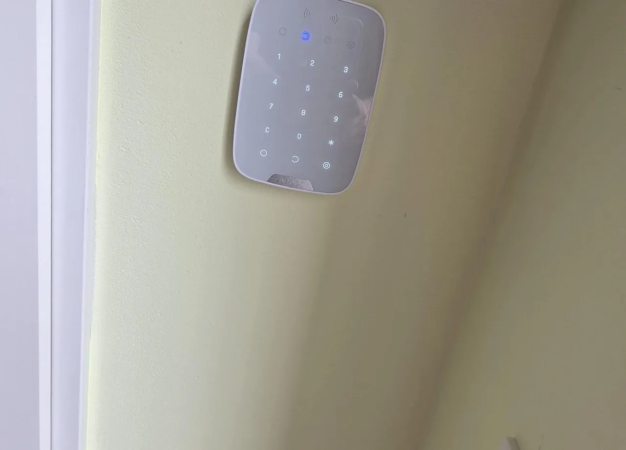 Ajax-camera op een muurbeugel bij de carport van een woning
