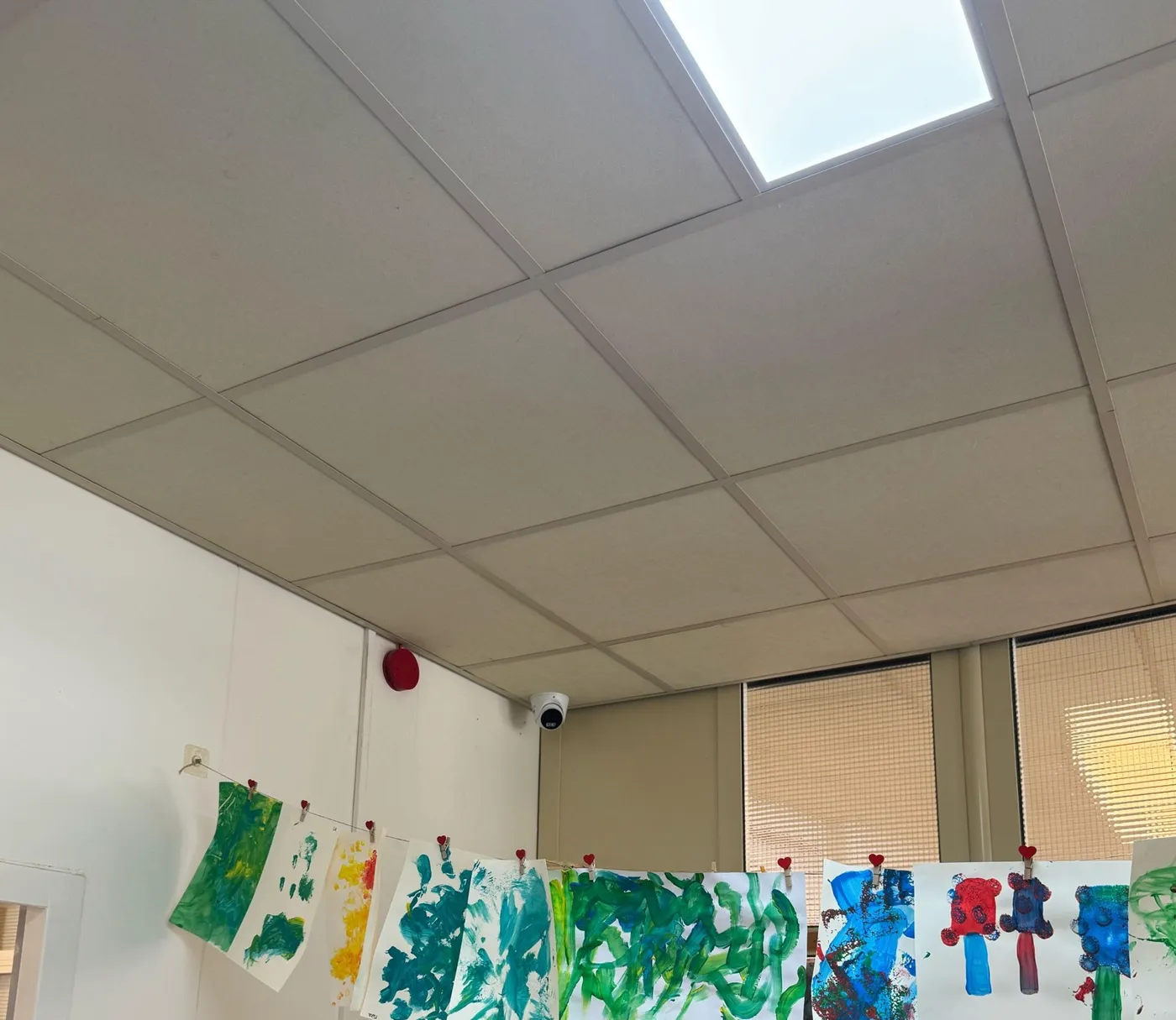 Witte camera naast een rookmelder aan het plafond van een groepsruimte in een kinderdagverblijf in Lelystad