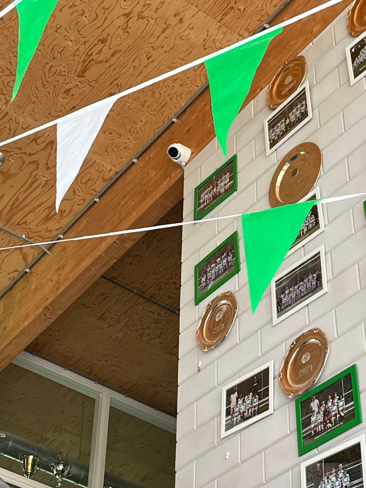 Domecamera hoog in de kantine van het clubhuis, tussen de vlaggetjes en teamfoto's