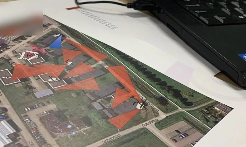 Cameraplan op papier met de zichtlijnen van elke camera op een luchtfoto