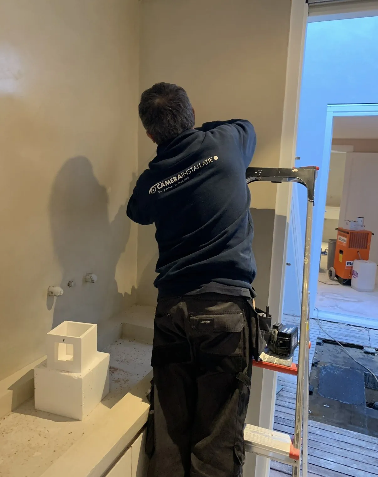 Aansluitingen worden afgewerkt in een woning in Amsterdam, voordat de wand wordt gesloten