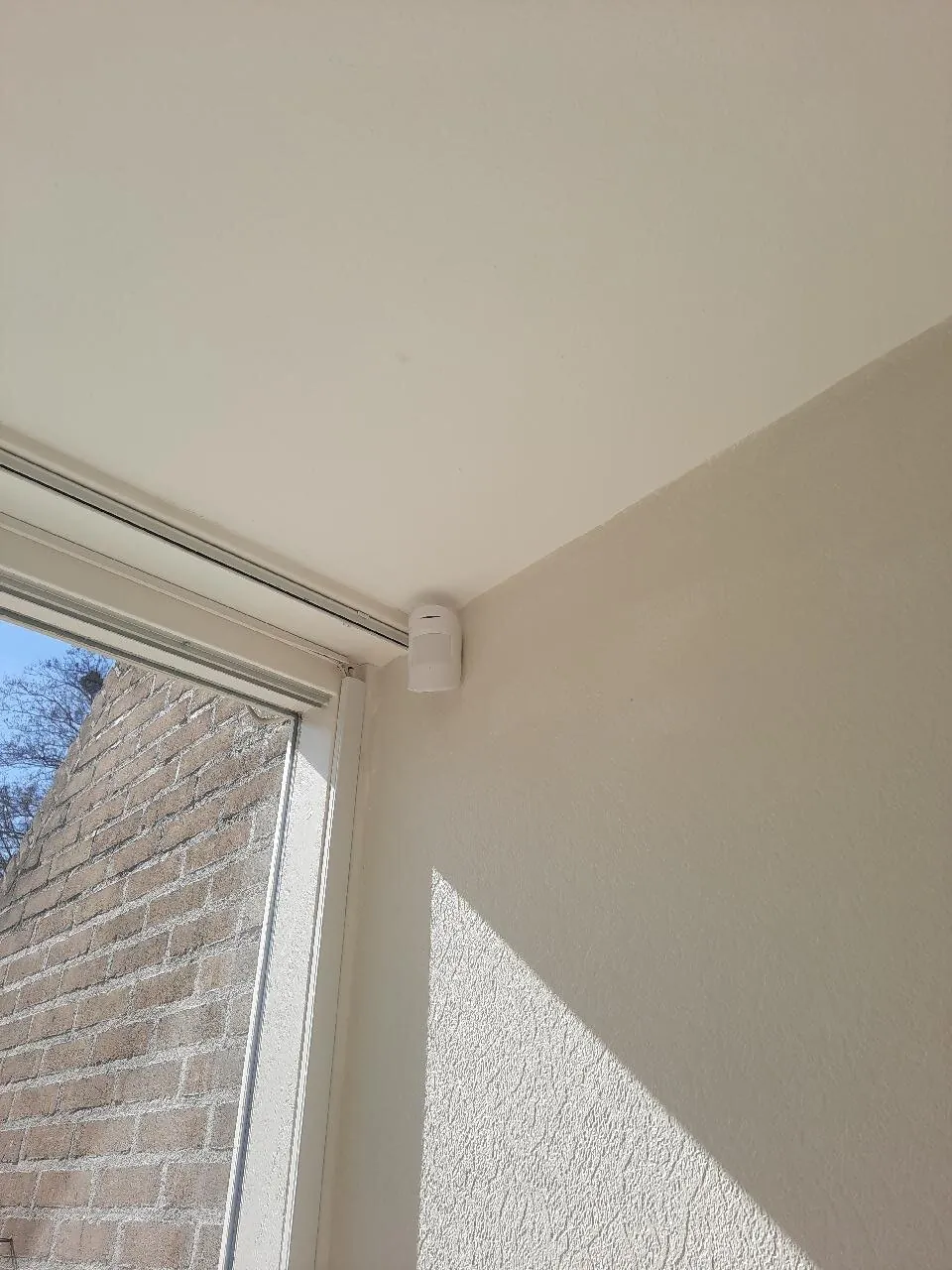 Witte bewegingsmelder van Ajax hoog in een kamerhoek naast het raam, Leidschendam