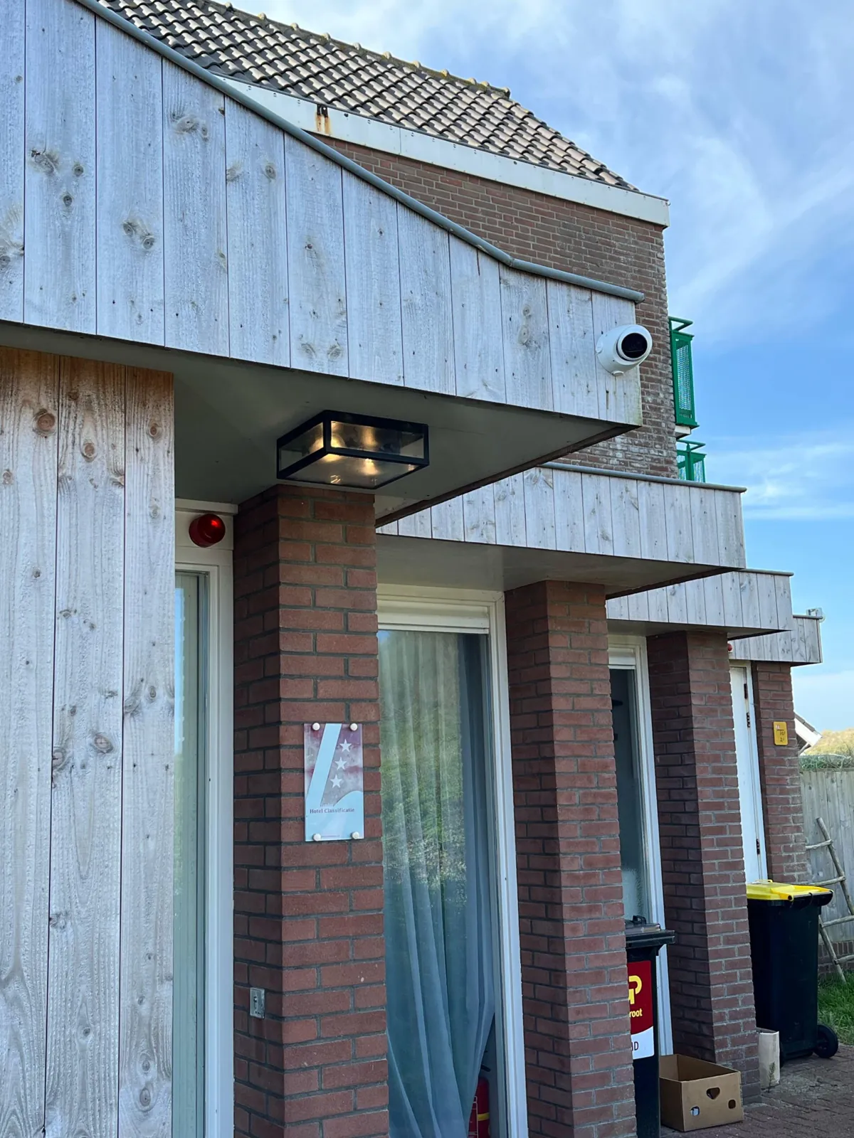 Witte camera onder de houten gevel bij de entree van een hotel in Bergen aan Zee