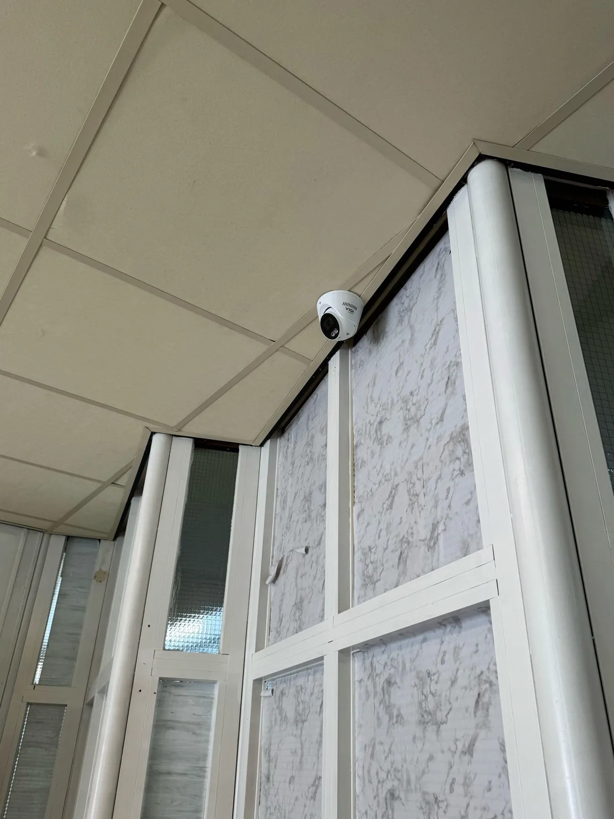 Camera aan het plafond naast een glazen wand in een school in Lelystad