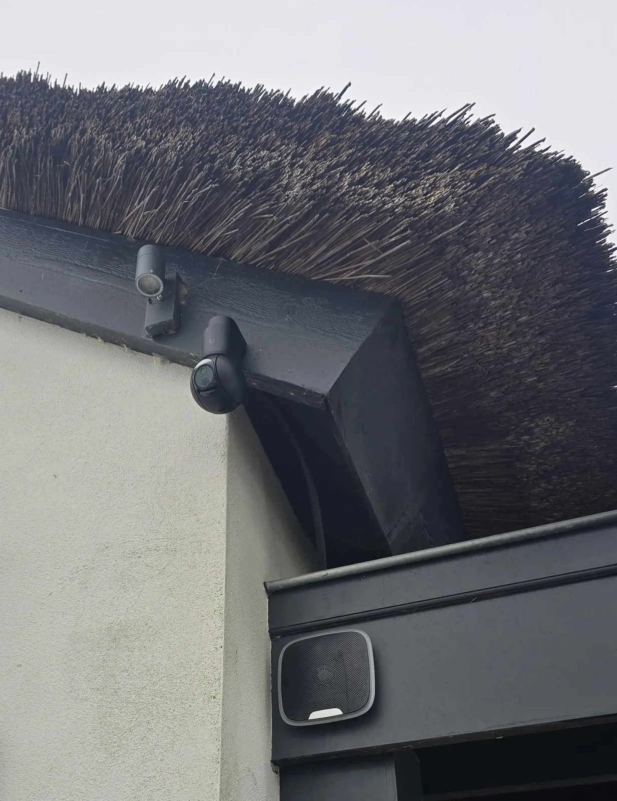 Camera onder de rieten dakrand van een villa in Montfoort, met lager een wifi-zender