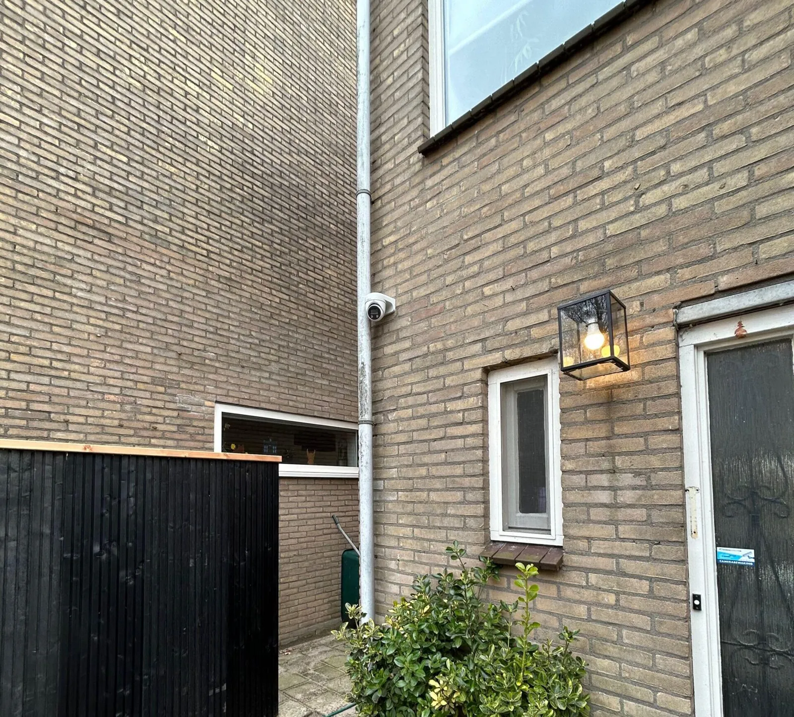 Witte camera hoog op de zijgevel in Lelystad, gericht op het steegje tussen de huizen