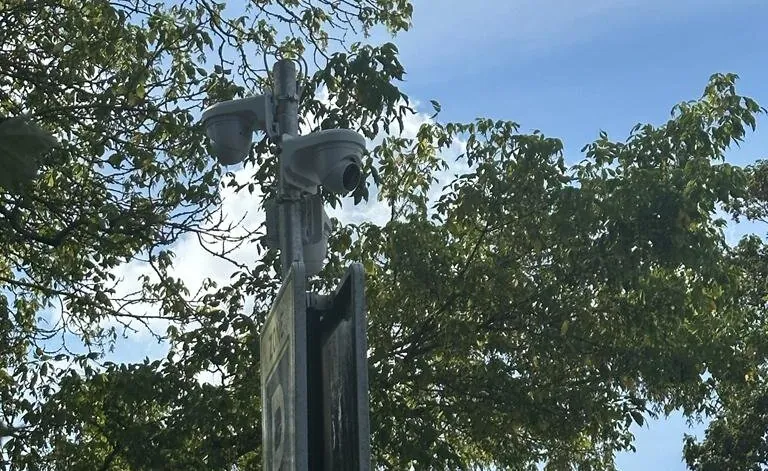 Twee witte camera's boven aan een lichtmast in Blaricum, tijdelijk opgehangen voor de feestweek