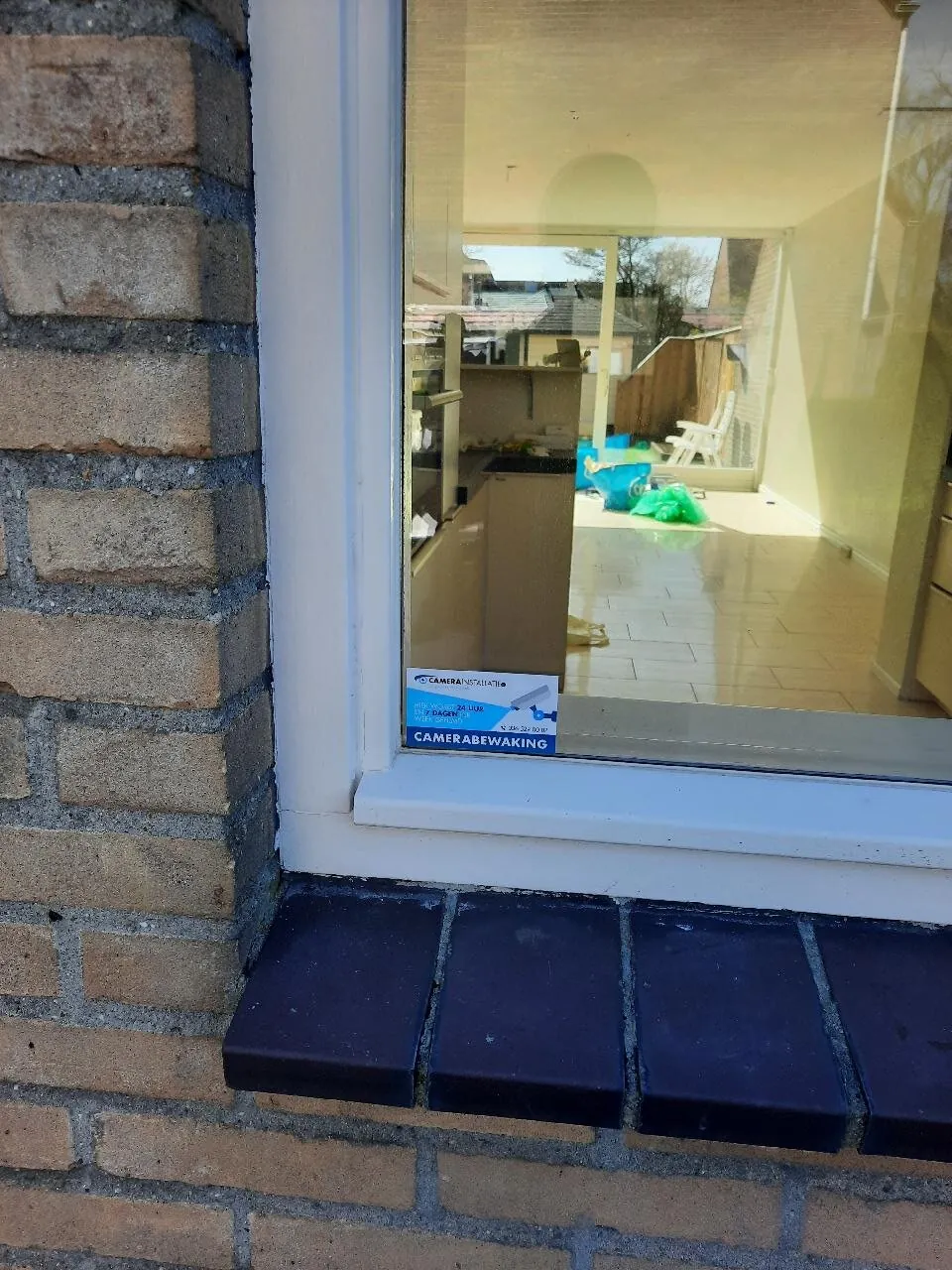 Camerasticker op de ruit van een woning in Leidschendam, met zicht op keuken en tuin