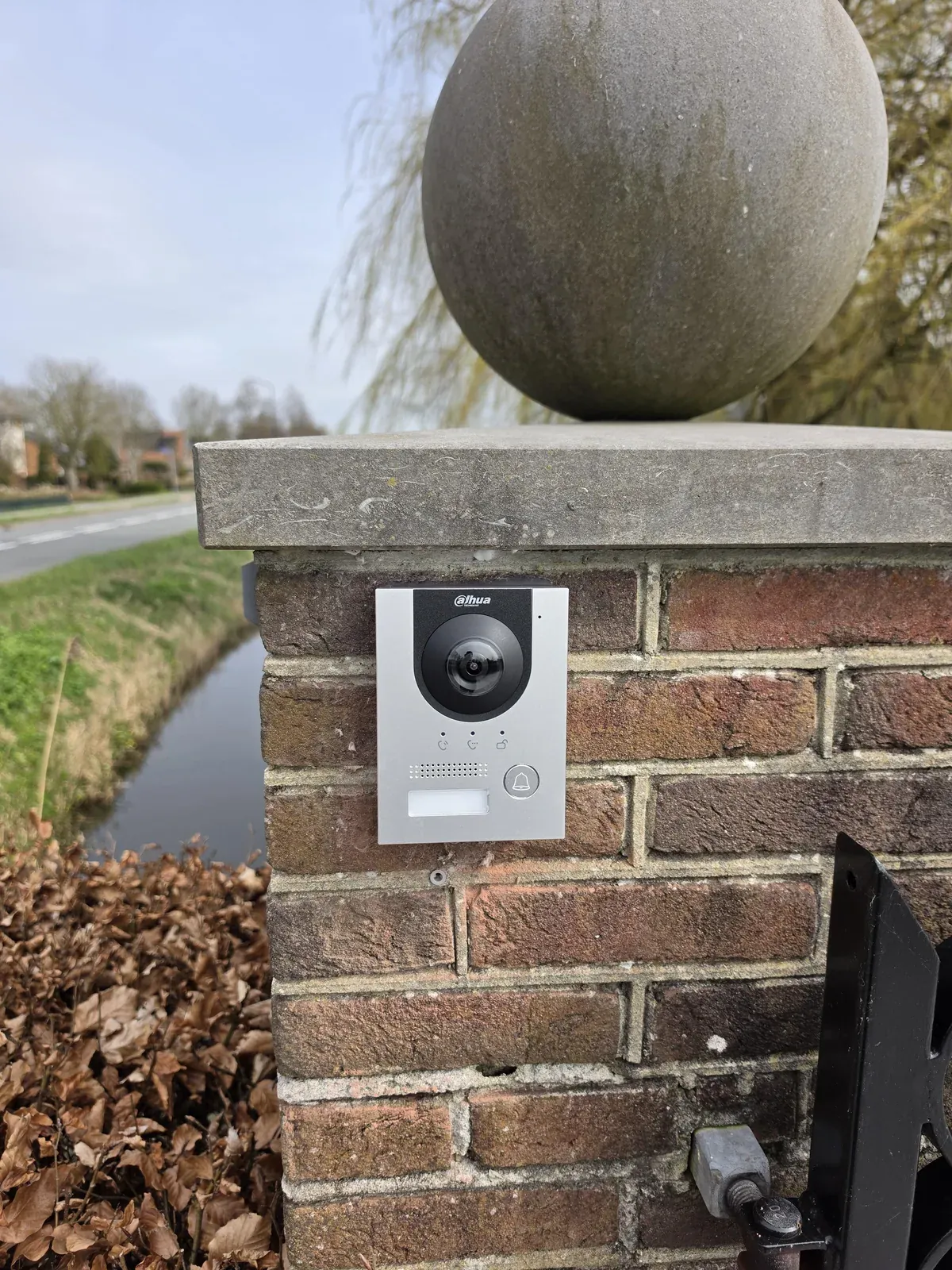 Zilveren Dahua-buitenpost in opbouw op een gemetselde poortpilaar bij een woning in Heerhugowaard