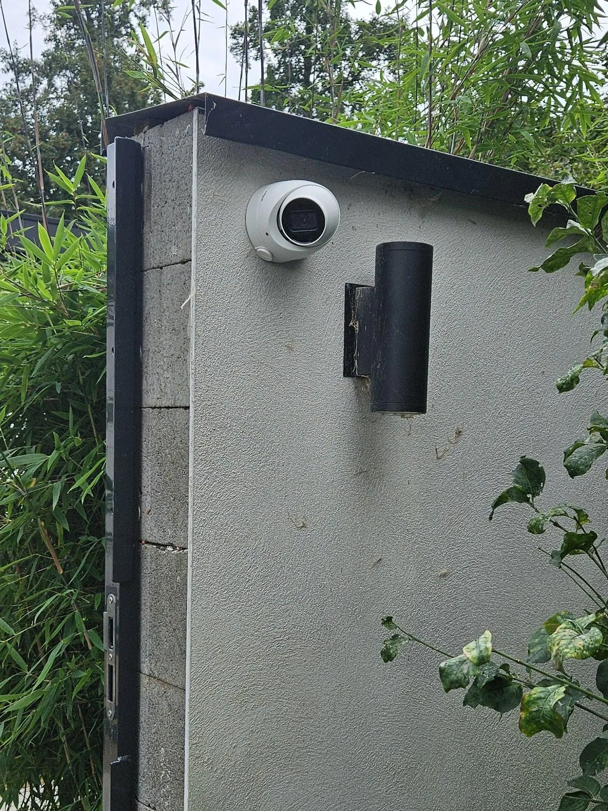 Witte Dahua-camera bij de achterpoort in Almere, met zicht op het achterpad