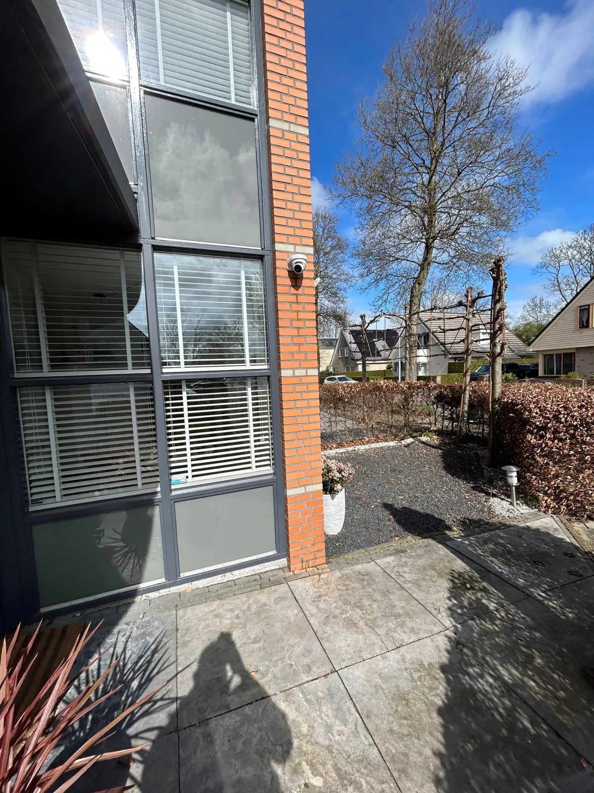 Witte Dahua-camera aan de gevelhoek van een nieuwe woning in Hoofddorp, zicht op tuin en oprit