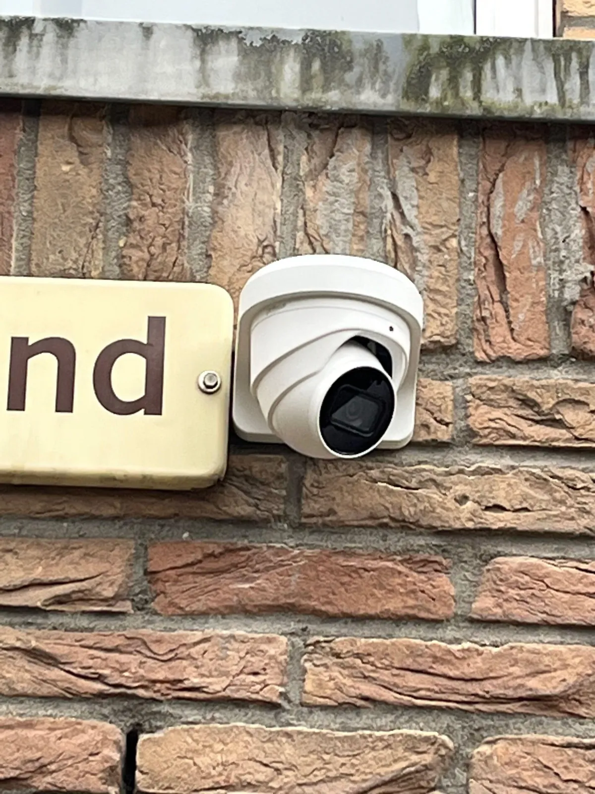 Dahua-turretcamera dicht tegen het metselwerk in Diemen, naast een emaille naambord