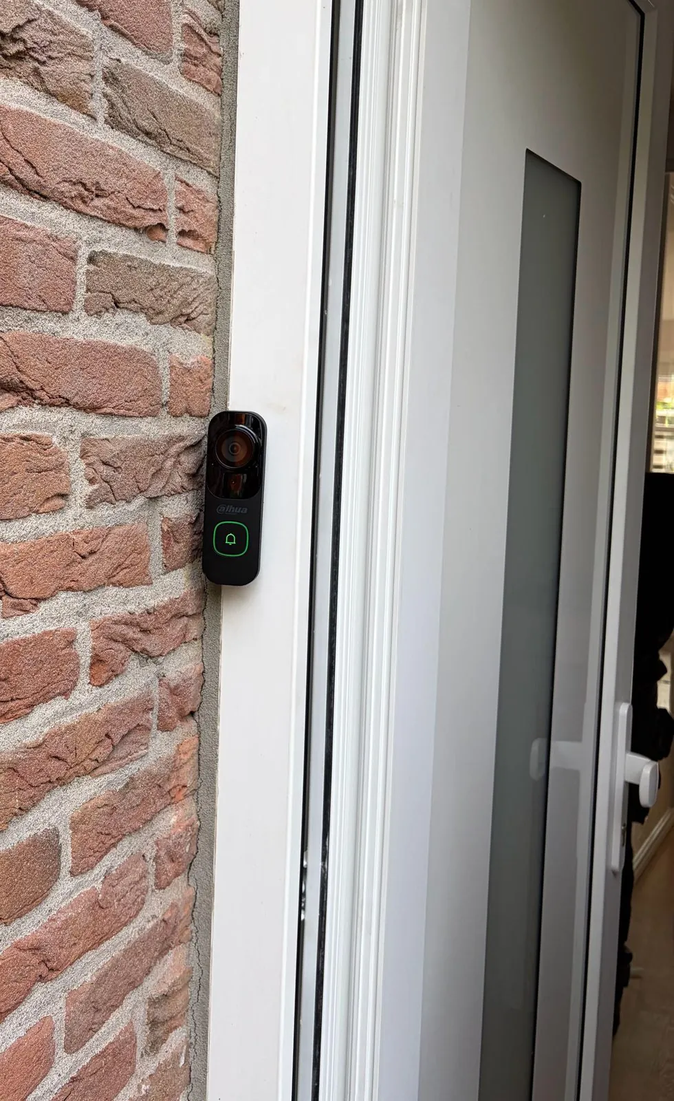 Dahua-videodeurbel met groene belknop naast de voordeur van een woning in Vinkeveen