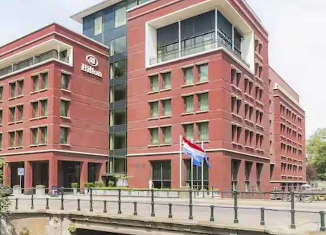 Het hotel in Den Haag aan de gracht, met hoofdingang en Nederlandse vlag