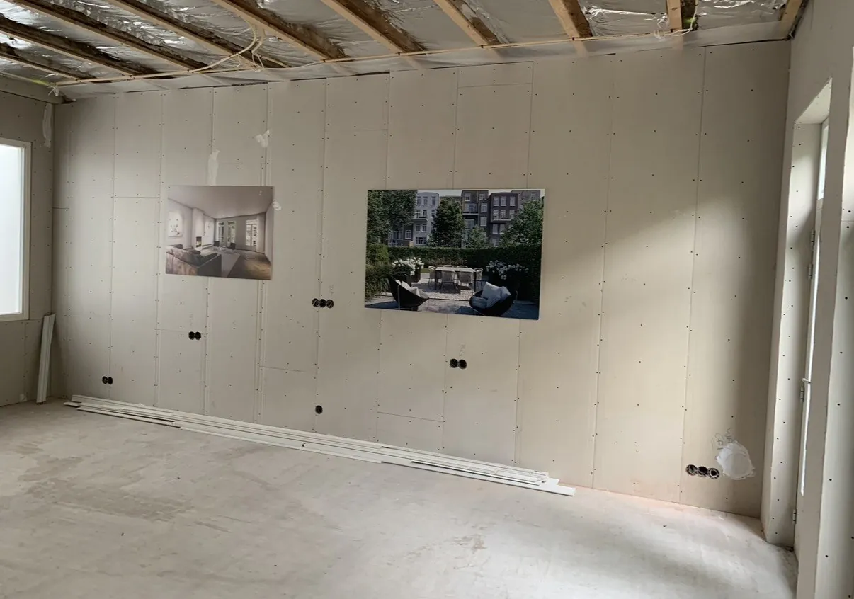 Kale wand in een woning in Amsterdam tijdens de verbouwing, met de inbouwdozen al op hun plek