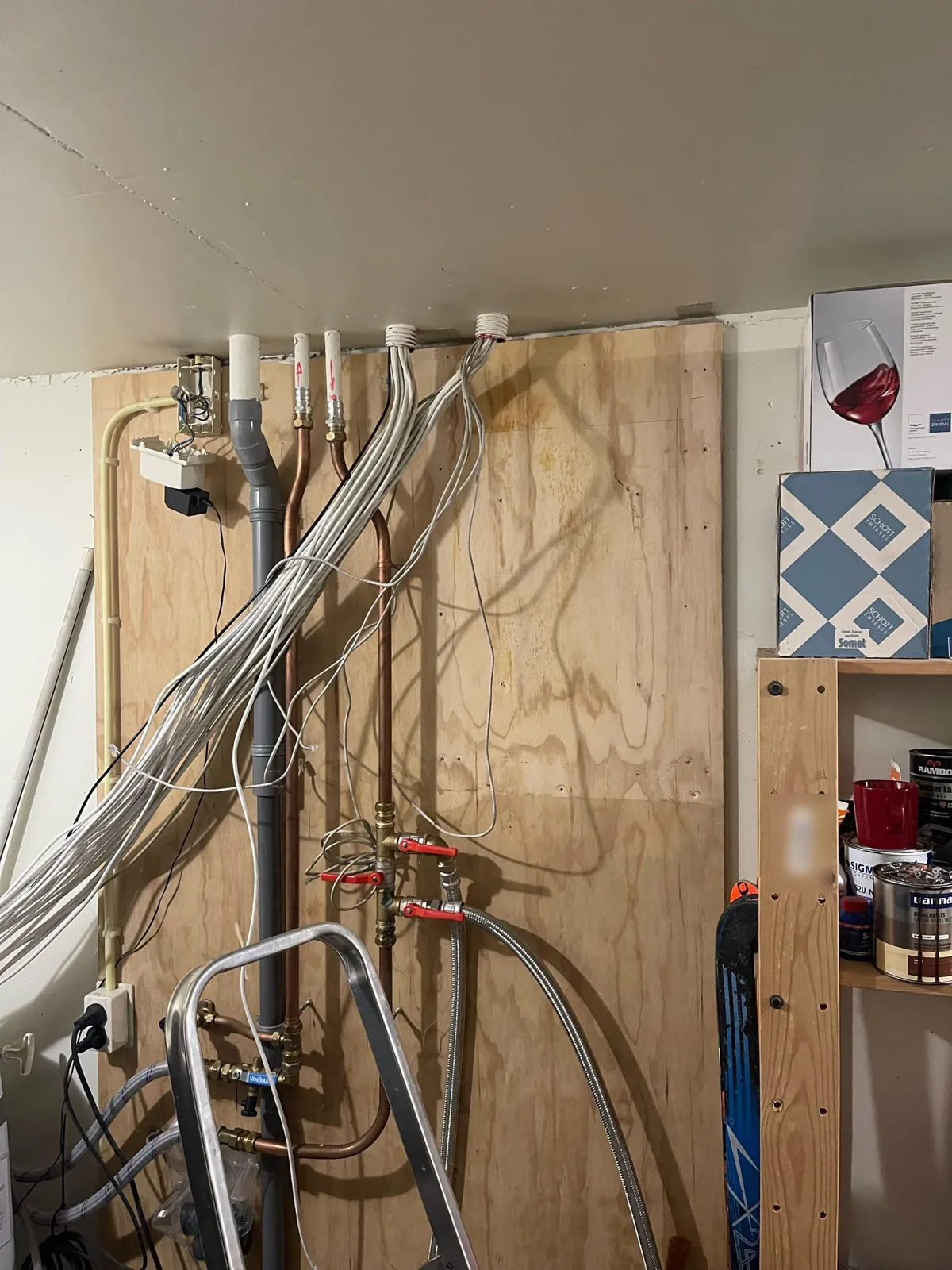 Bundels witte netwerkkabel hangen nog los tegen het hout in Buren, voor het rek kwam