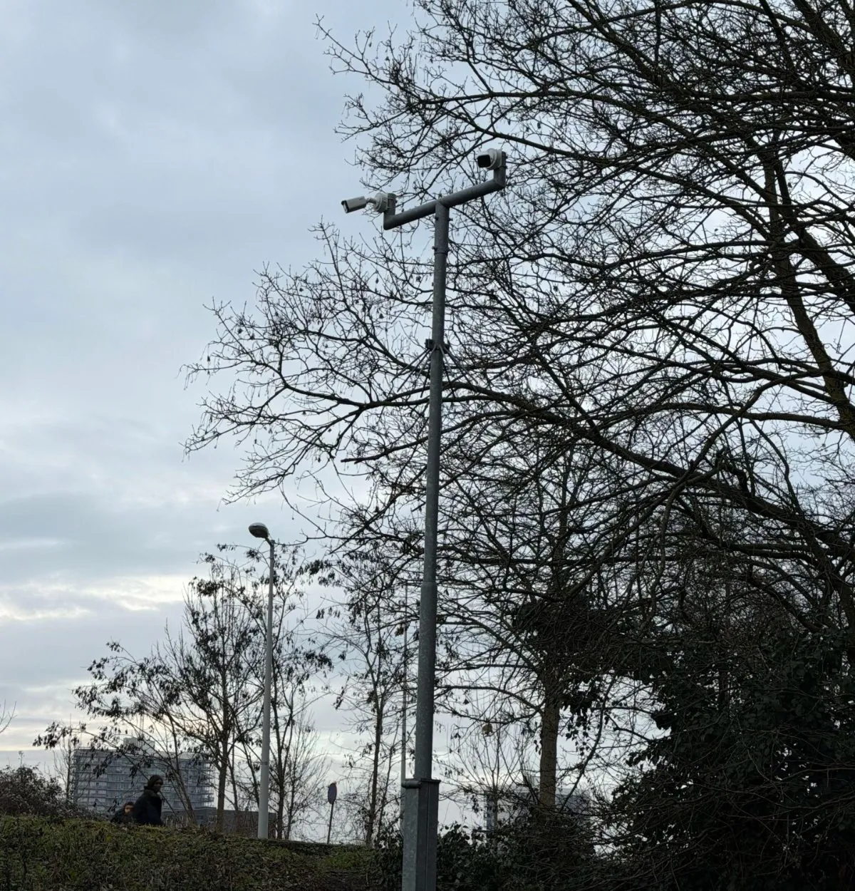 Hoge mast met camera boven het gezamenlijke terrein tussen de woonblokken