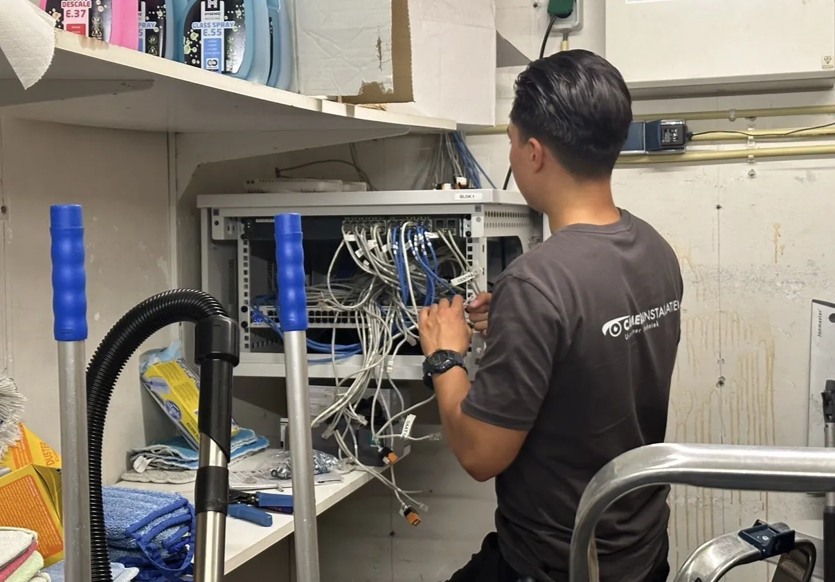 Nieuwe switch en opnieuw gepatchte bekabeling in de wandpatchkast van het hotel in Vught