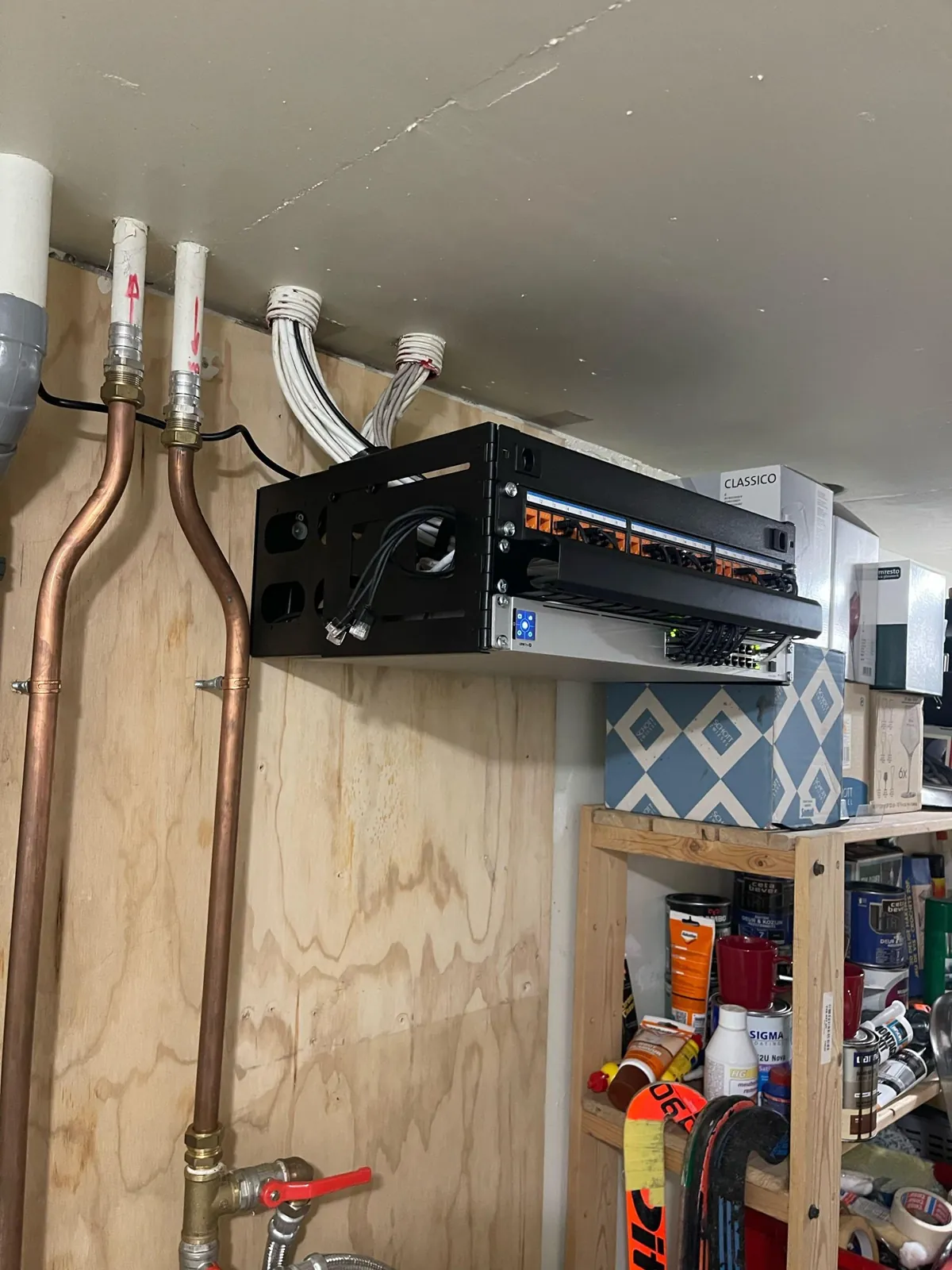Open rek van 4U aan een houten wand in Buren, met genummerde keystones en een UniFi-switch