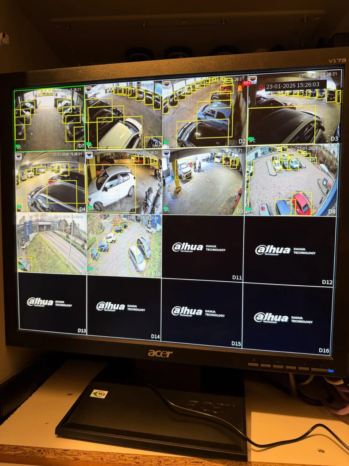 Monitor met live beelden van het complex en gele kaders rond personen en voertuigen