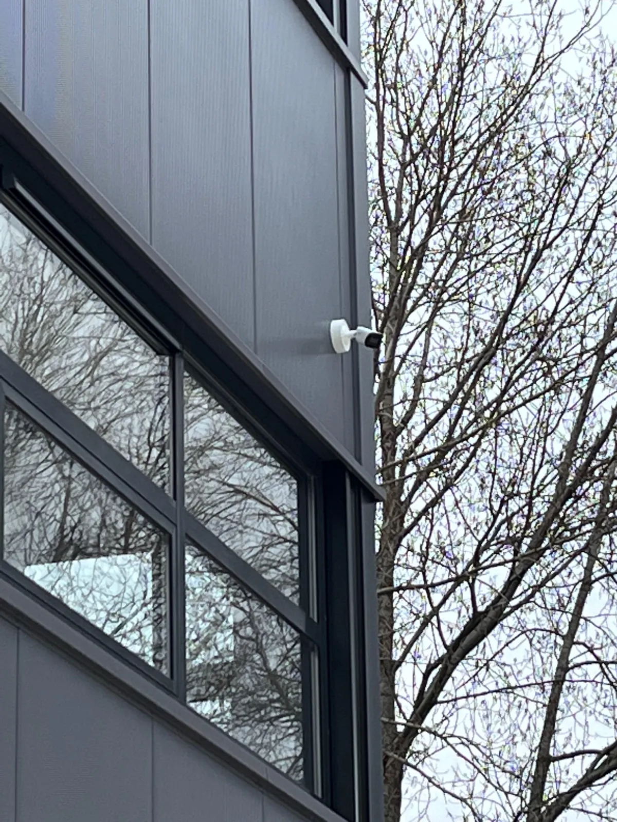 Stalen buis met een bocht beschermt de kabel tussen grond en gevel in Amsterdam