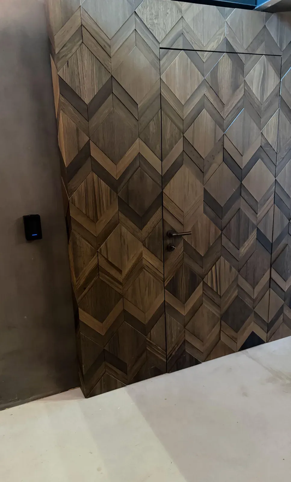 UniFi-toegangslezer naast een bijna verborgen deur in de houten ruitwand van een pand in Hilversum