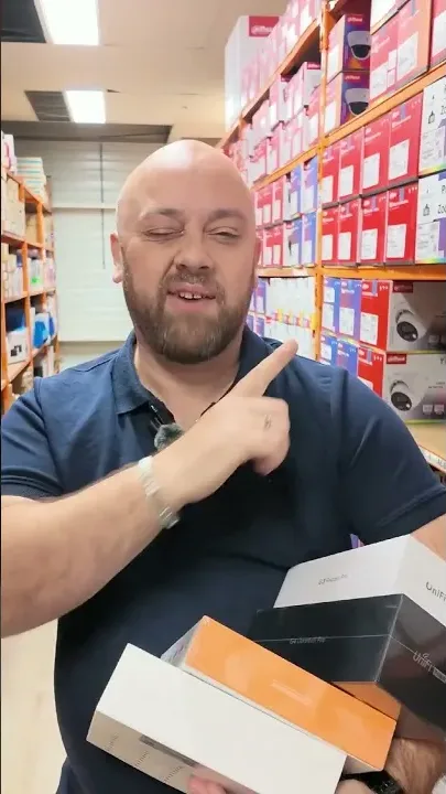 Geoffrey in ons magazijn met een stapel dozen van videodeurbellen