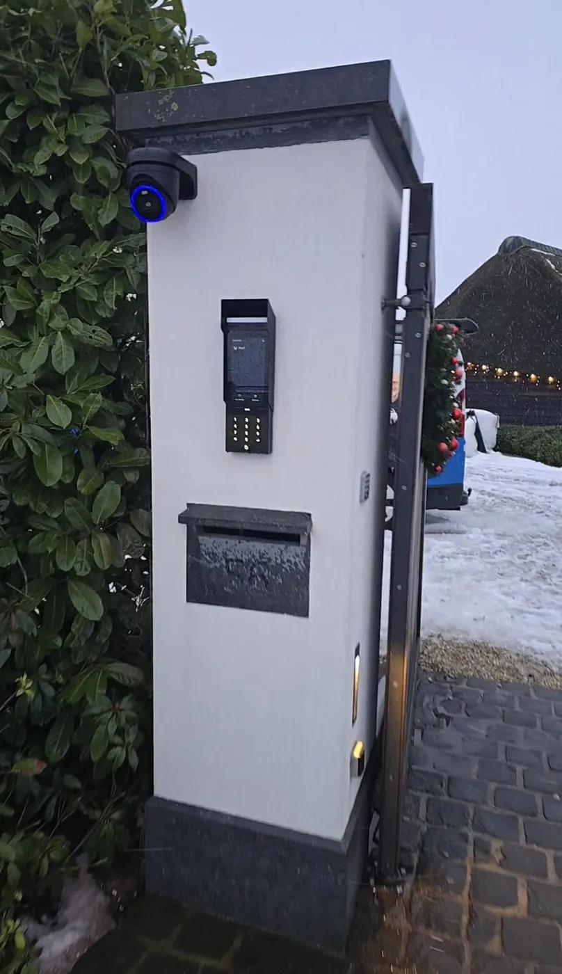 Witte zuil bij een oprit met intercom, brievenbus en camera in Montfoort