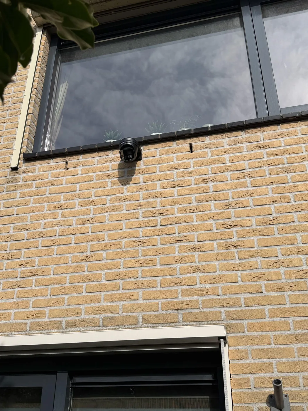Zwarte Dahua-camera met twee lenzen voor 180 graden zicht op een gele gevel in Utrecht